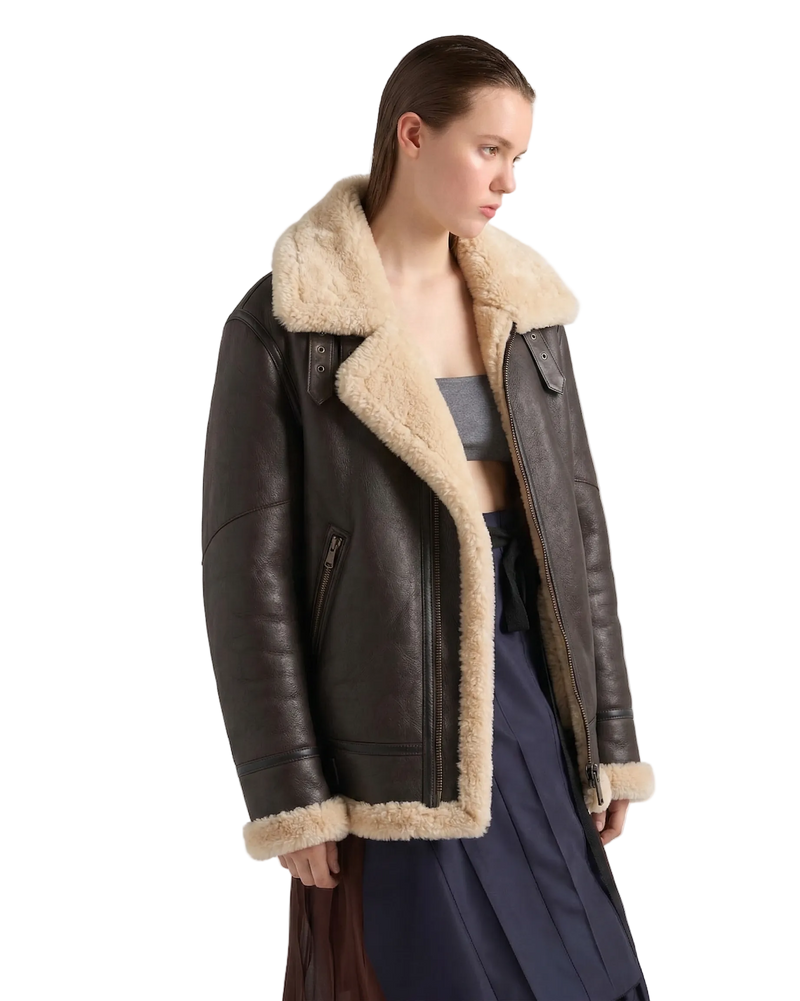 Close-up of the buckle-fastened storm collar on a women's brown aviator jacket.